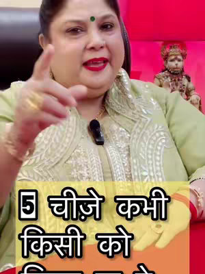 The cover image features a woman pointing towards the viewer with her right hand. The woman, with a round face, is wearing makeup, including red lipstick and a green dot on her forehead. She's wearing a light green embroidered jacket and a gold necklace, set against a red background with a small statue in the background. The overlay text in Hindi is visible at the bottom of picture in a yellow background