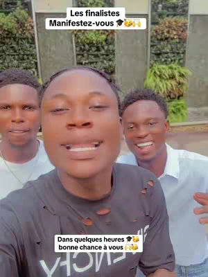 A selfie-style video featuring three young men smiling at the camera. The central figure is in the foreground, and the other two are positioned slightly behind him, with a lush green background. The main subject wears a black t-shirt, while the others are in white. Text overlays are placed at the top and bottom of the image.