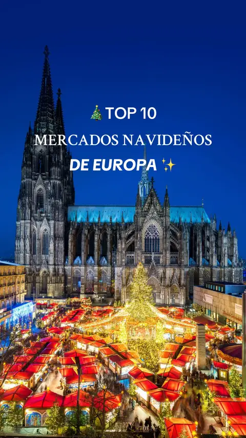 An eye-level shot captures a night scene in a European city, showcasing a Christmas market at the bottom. Illuminated stalls with red roofs are arranged densely, creating a warm, inviting glow. Overhead, the imposing structure of a cathedral fills the frame, its dark stone facade lit in blue and white. Text at the top reads 'TOP 10 MERCADOS NAVIDEÑOS DE EUROPA,' indicating a ranking of Christmas markets.