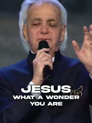 The cover image features a man with white hair, wearing a dark suit, and holding a microphone. The man has his eyes closed and appears to be emotional while speaking or singing. Text overlays on the image read, "JESUS WHAT A WONDER YOU ARE" with an emblem next to the word JESUS