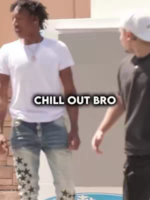 Two young men are in a casual outdoor setting. The man on the left, in a white t-shirt, jeans with star patterns, is looking at the man on the right, slightly out of frame. The man on the right wears a white cap and dark t-shirt. The text "CHILL OUT BRO" is overlaid on the image.