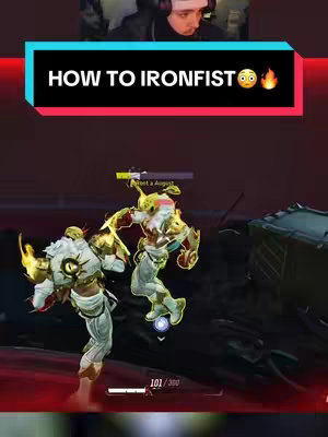 The cover image shows the video creator with a game interface overlayed. Overlaid on the screen is a text overlay with the title "HOW TO IRONFIST," complete with an emoji that seems to indicate surprise and another that is the fire emoji, along with the creator's face in the top right corner. In the foreground, a game scene shows two characters in the game locked in combat. The background is dark with a red tint.