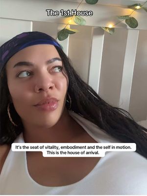 A young woman with dark hair and a patterned headscarf looks off to the side with a slight smile. Text overlays at the top and bottom explain the video's topic. The background is a white room with lights.