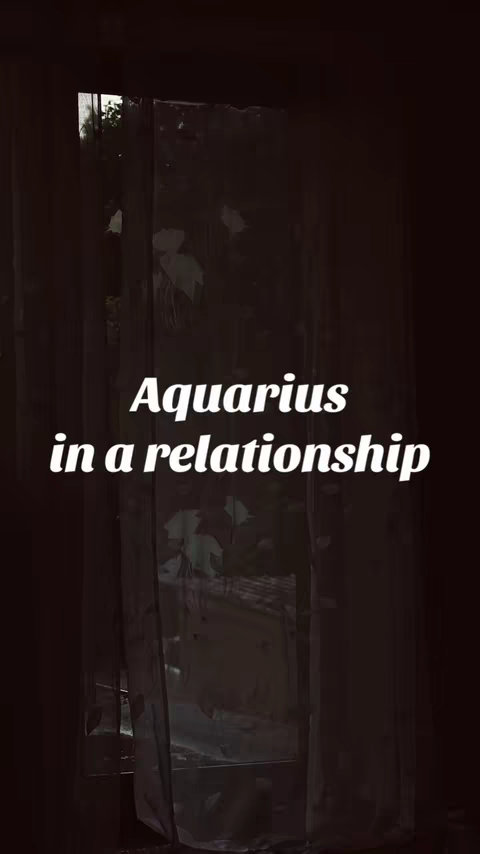 The image features a dark, moody aesthetic. A window with slightly dirty glass is the central focus, framed by dark brown or black wooden structures, creating a sense of enclosure. Through the window, a glimpse of trees hints at an outdoor setting, with varying shades of green and brown suggesting foliage. Overlaid in the center is white text that reads \"Aquarius in a relationship\", using a clean, readable font.