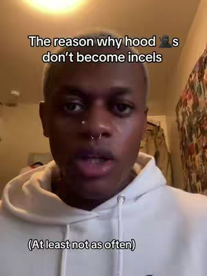 A person of color with short, light-colored hair is speaking directly to the camera. They're wearing a white hoodie. The background is a blurry interior setting. Text overlays are placed at the top and bottom of the frame.