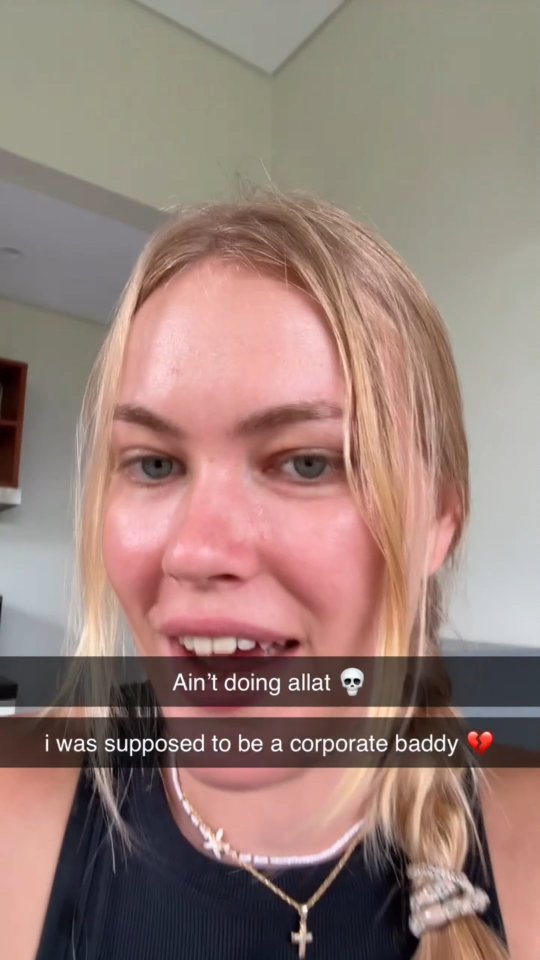 A selfie-style shot featuring a blonde woman with a slight smile, her blonde hair is partially braided. She is wearing a cross necklace and a black top. Text overlays express a humorous disappointment. The background is slightly blurred, suggesting an indoor setting.