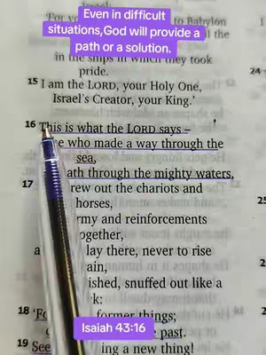 The image captures an open Bible with highlighted text and a pen pointing at it. Overlaid text in the top left states "Even in difficult situations, God will provide a path or a solution." A lower overlay indicates "Isaiah 43:16". These elements are set against a background of the Bible's pages, with a focus on a key verse.