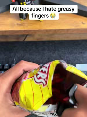 A person's hands are opening a bag of chips. Text is overlaid at the top of the image.