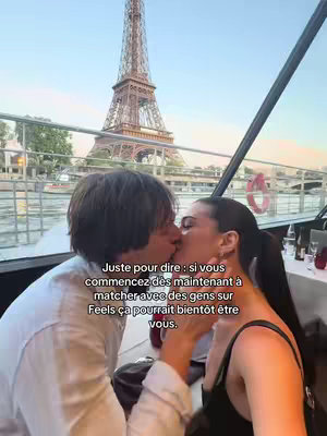 A couple is kissing on a boat in front of the Eiffel Tower. The image is well-lit with the tower prominently featured in the background, and text is overlaid at the bottom of the image.