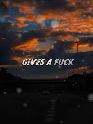 The image shows a road leading towards the horizon with a vibrant sky filled with orange and blue hues. The words 'GIVES A FUCK' are superimposed on the image in bold, white text.