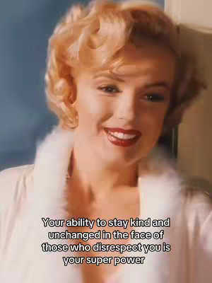 A close-up shot of a woman, reminiscent of Marilyn Monroe, with blonde, softly curled hair. She is wearing a fluffy white robe, and is smiling at the camera, with red lipstick visible. Text overlays are placed at the bottom: Your ability to stay kind and unchanged in the face of those who disrespect you is your super power.