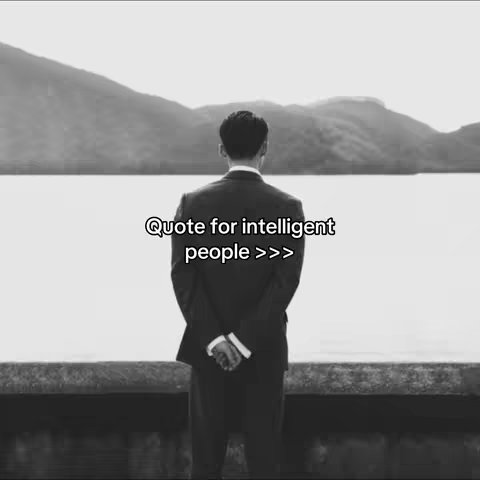 A grayscale image of a man from the back, wearing a suit and facing away from the camera towards a body of water and mountains. Text overlayed at the bottom reads 'Quote for intelligent people >>>'.