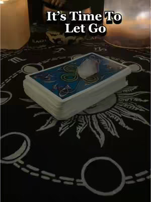 The cover image shows a stack of tarot cards with a white quartz crystal on top. The cards are on a dark surface, likely a cloth, with a circular pattern. The words "It's Time To Let Go" are superimposed on top of the image.