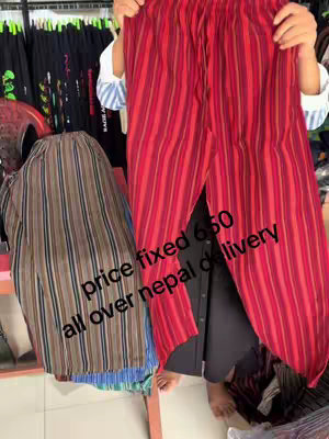 A person holds up two pairs of clothing. One on the left is a patterned shirt, and the one on the right is red striped pants. Text overlays indicate the price and delivery details.