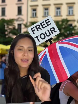 A woman is holding a sign that says "FREE TOUR" while standing in a city. She is smiling and has a Union Jack style umbrella behind her. The image has a bright and colorful, daytime look, with a blurred background of buildings.