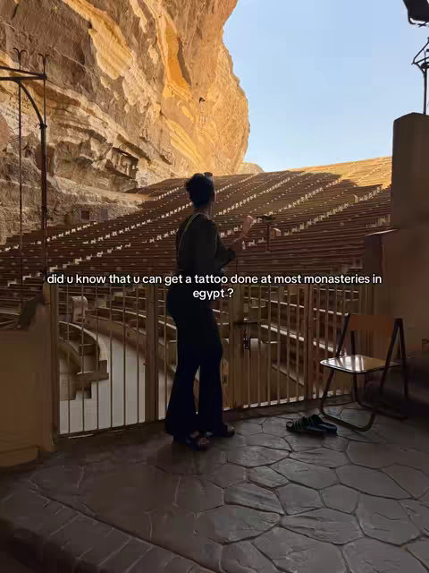 The cover image shows a woman standing while looking up at a rock formation behind a gate. The woman wears black pants and a dark green shirt. Sandals sit on the floor nearby.