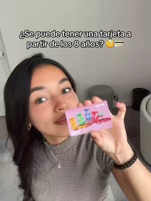 A woman holds a pink credit card, looking at the camera with a playful expression. Text overlayed on the image is a question.