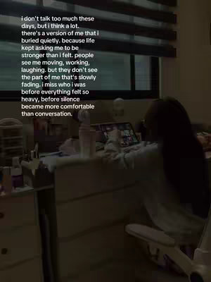 The image shows a dimly lit room. The focus is on a person sitting at a desk with a laptop open, though the person's face is not visible. Text overlays the image, describing feelings of emotional isolation.