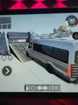 A screenshot from a mobile game showing a gray van driving up a ramp on a track made of concrete blocks. The game's HUD includes driving controls and a speedometer.