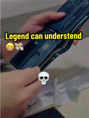 A person is holding a dark blue wallet open. Inside the wallet, an American Express credit card is visible. An emoji is superimposed on the left, and a drawn skull on the right.