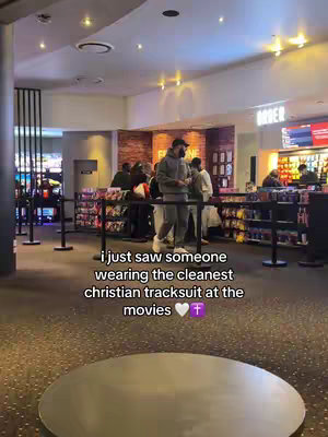 A photo taken in a movie theater. A person wearing a grey tracksuit is in the foreground with the hook text overlaid at the bottom.