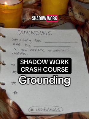 A close-up shot of a piece of paper with handwriting on it. The words "Grounding" and "Shadow work" are visible along with a few bullet points. In the background are candles and cloth.