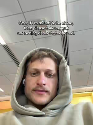 A selfie-style shot featuring a man in a hoodie. He is looking directly at the camera with a neutral expression. Overlayed on the top of the image is white text.