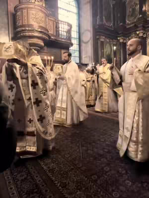 The cover image shows a scene inside a church, with multiple people in religious attire. The setting includes a large, ornate interior with high ceilings, possibly a cathedral or a similar religious building, and the people are positioned along a central aisle, likely during some religious ceremony.