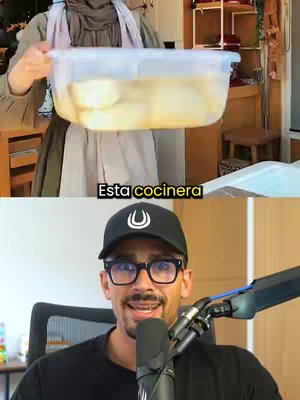 The image is split horizontally. The top half shows a person in an apron holding a large, clear plastic tub filled with liquid, with what appears to be food submerged in it. They are in a kitchen-like setting. The bottom half features a man wearing a black baseball cap, glasses, and a black shirt, speaking into a microphone. The text overlay reads 'Esta cocinera'.