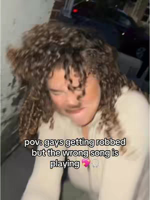 The image shows a person’s face with curly hair, angled slightly downward. The person appears to be reacting, with a surprised or concerned expression. Text overlays the image.