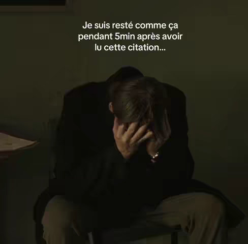 The image shows a man sitting with his head in his hands, seemingly in distress or contemplation. He is wearing a dark coat or jacket and appears to be indoors. Text is overlaid on the image, suggesting a reaction to something read.