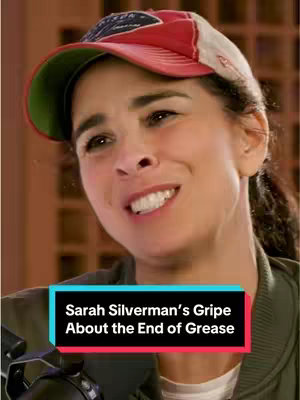 The cover image features a woman, Sarah Silverman, smiling and looking towards the side. She's wearing a baseball cap and a green jacket. A text overlay in a colorful box reads "Sarah Silverman's Griepe About the End of Grease". The background is a tan wall.