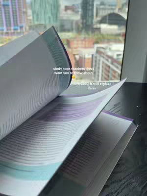 The cover image shows an open book angled towards the viewer. The pages are made of white paper with text, a teal and purple accent. Through the open book, a building can be seen. There's text overlayed in the image with a white font.