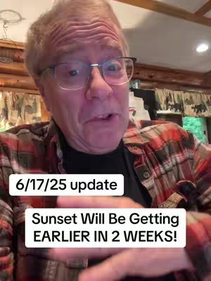 A man with glasses is speaking to the camera. The man wears a plaid shirt. Two text boxes with white backgrounds sit at the bottom of the frame. One reads "6/17/25 update" and the other says "Sunset Will Be Getting EARLIER IN 2 WEEKS!". The background appears to be a wall of wood panels.