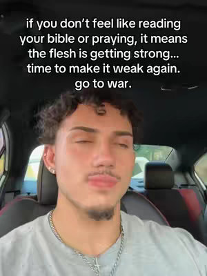 A selfie shot with a man in a car, text overlayed. The man has short, curly brown hair, a trimmed mustache and goatee, and is wearing a gray t-shirt and a silver necklace. He is looking at the camera with closed eyes and a slight pout. The background shows car's interior. Text overlay in black and white above.
