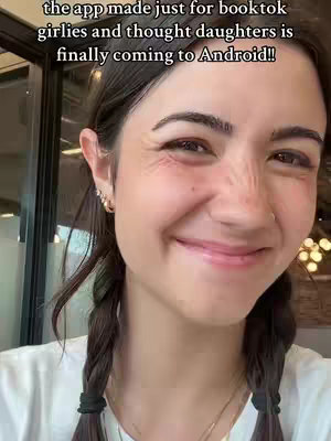 The cover image shows a young woman from the chest up, with her face filling most of the frame. She has dark hair, styled into two braids, and is wearing a white t-shirt and some gold earrings. She is smiling, with a slightly flushed complexion. The background is blurred and appears to be an indoor setting.