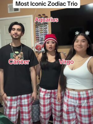 The cover image features three people posing together. On the left is a man in a black t-shirt and red and white checkered pajama pants labeled "Cancer" and with a gold chain. The middle person is a woman wearing a black top and red beanie, labeled "Aquarius". On the right, a woman in a white tank top and red and white checkered pajama pants is labeled "Virgo". The background suggests an indoor setting.