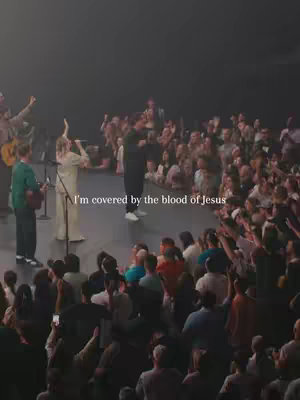 A live stage with a large crowd and a performer in the center. Warm stage lighting emphasizes the performer with the crowd in the background.