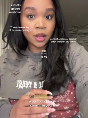 A selfie-style cover image showing a woman with dark hair and makeup, looking directly at the camera. Text overlays are scattered around her, including inspirational phrases and time notations. She wears a torn gray sweatshirt over a red and white patterned top. She appears to be holding an object in the bottom part of the frame, possibly cards or a deck.