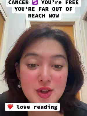 A woman with dark shoulder-length hair is centered in the selfie-style shot. She is looking directly at the camera. Above the top of her head are capitalized lines of text, with a zodiac symbol inserted between them. Below her is a heart emoji followed by the words 'love reading.'
