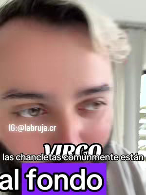 The cover image features a close-up shot of a light-skinned man with blond-highlighted hair and a trimmed beard. He's looking towards the right, showing his eyes and part of his face. The background is slightly blurred, suggesting an indoor setting. Overlaid on the image are text elements. The text "VIRGO" appears in bold white letters on a black bar. Beneath that, other text is placed on a purple rectangle that reads " las chancletas comúnmente están al fondo" in a large, easy-to-read font.