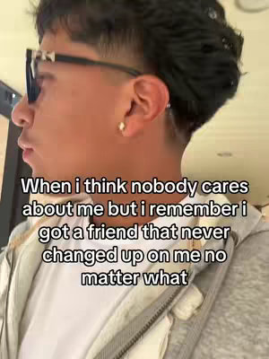 A person with dark hair wearing sunglasses and a white shirt stands with their head turned to the left, seemingly in an indoor setting. Text overlayed on the image reads a message about remembering a friend.