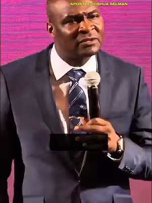 The cover image features a medium shot of a man in a dark suit, holding a microphone, and speaking to an audience. Behind him, a textured, pinkish-purple background creates a solid backdrop. The man, who has short, dark hair and a focused expression on his face, is centered with the upper portion of his body framed.