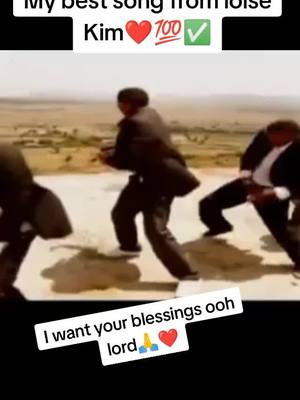 The image shows three men in suits performing a dance on a light-colored surface, likely a stage or outdoor area, with a vast, light-brown landscape acting as the background. Written overlaid graphics include the text overlay on the top middle of the image showing "My best song from ...". In the lower part of the image overlay contains the phrase "I want your blessings ooh lord".
