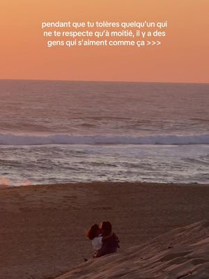 A serene beach scene at sunset. The foreground features a sandy beach with two figures embracing each other.  The background comprises the ocean and a colorful sky painted with shades of orange and pink.
