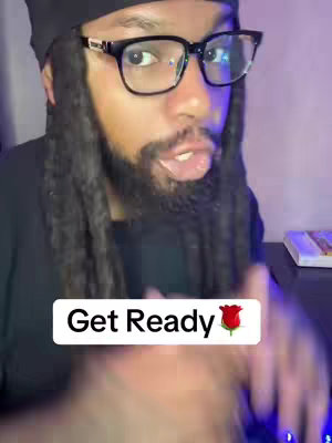 A man wearing a black beanie, glasses, and a black shirt is speaking directly to the camera. The background has a purple and blue hue, suggesting a potentially lit workspace. A text overlay, 'Get Ready 🌹', is at the bottom, highlighting an anticipation theme.
