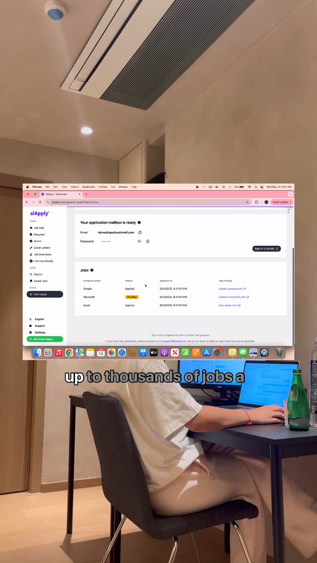 The video shows a person sitting at a desk working on a laptop. The laptop screen displays a website or application. The background includes a ceiling, air conditioning, and parts of room.