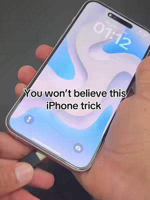 The cover image shows a close-up view of an iPhone held in a person's hand. The phone screen displays a modern, abstract wallpaper with blue and white flowing shapes. A charging cable is inserted into the phone. Text overlaid on the image reads, 'You won't believe this iPhone trick'.