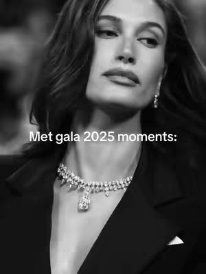 A black and white close-up shot of a woman with wavy hair, wearing a black jacket and diamond necklace. Text overlay reads 'Met gala 2025 moments:' in white font.