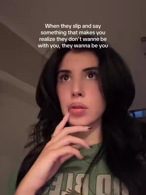 A medium shot features a young woman with dark hair looking slightly upward with a thoughtful expression. She's wearing a green t-shirt and has her right hand raised, fingers touching her lips. Above her, white text overlays the image.